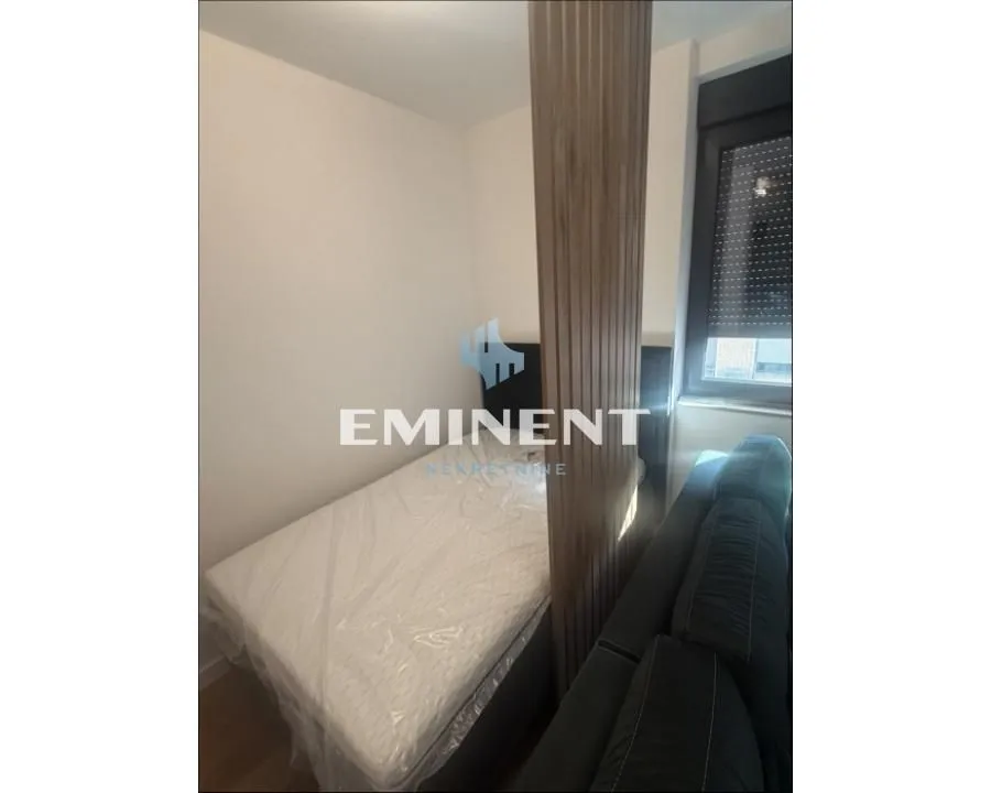 Smaller bedroom with a bed and a decorative wooden panel.