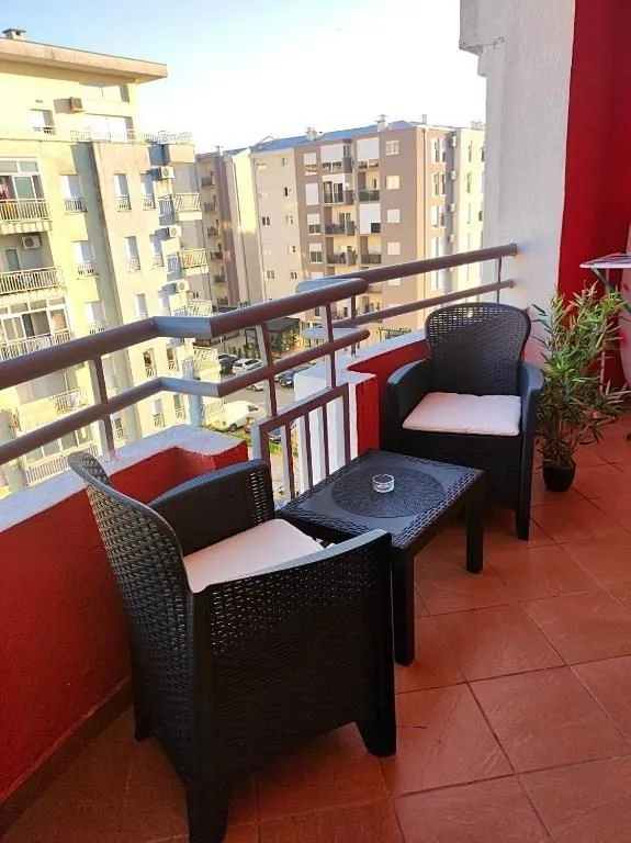 Balkon sa dvije stolice, malim stolom i pogledom na okolne zgrade.