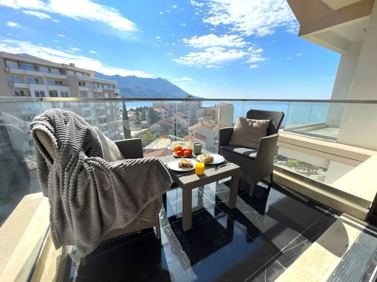 Furnished balcony with seating set and sea view.