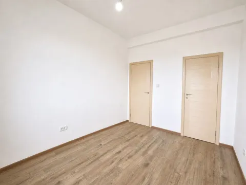 Prazna soba sa bijelim zidovima, drvenim podom i dvoja vrata. - image 5