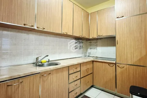 Kitchen with wooden cabinetry, a sink, and built-in home appliances. - image 8