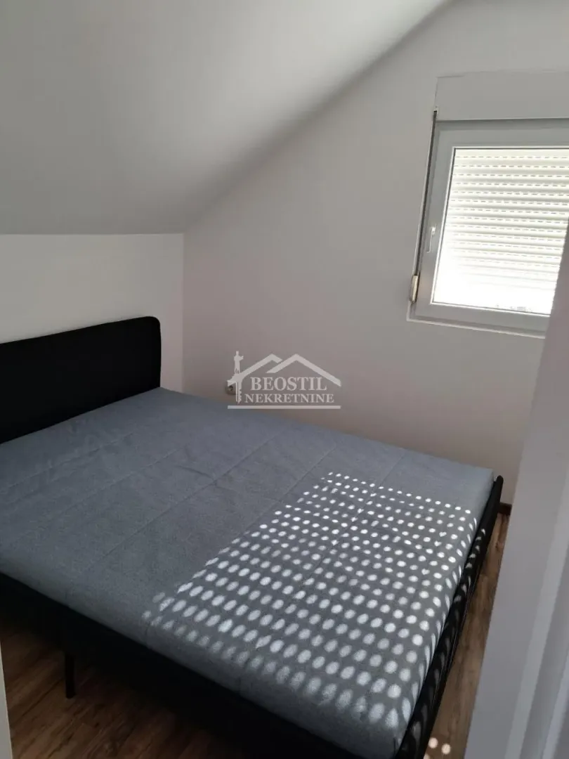 Smaller bedroom with a double bed under a sloped ceiling.