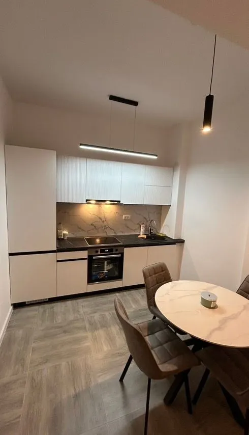 Modern kitchen with a dining table and built-in appliances.