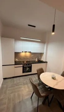 Modern kitchen with a dining table and built-in appliances. - image 3