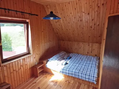 Spavaća soba obložena drvetom sa kosim plafonom u planinskom stilu. - image 2