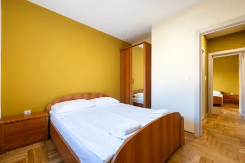 Furnished bedroom with a double bed and a wooden wardrobe. - image 6