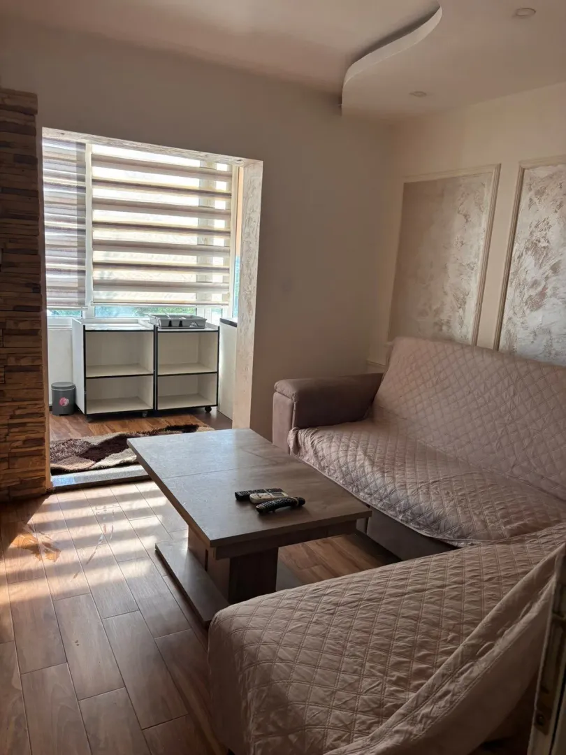 Living room with a sofa and table, with access to the terrace.