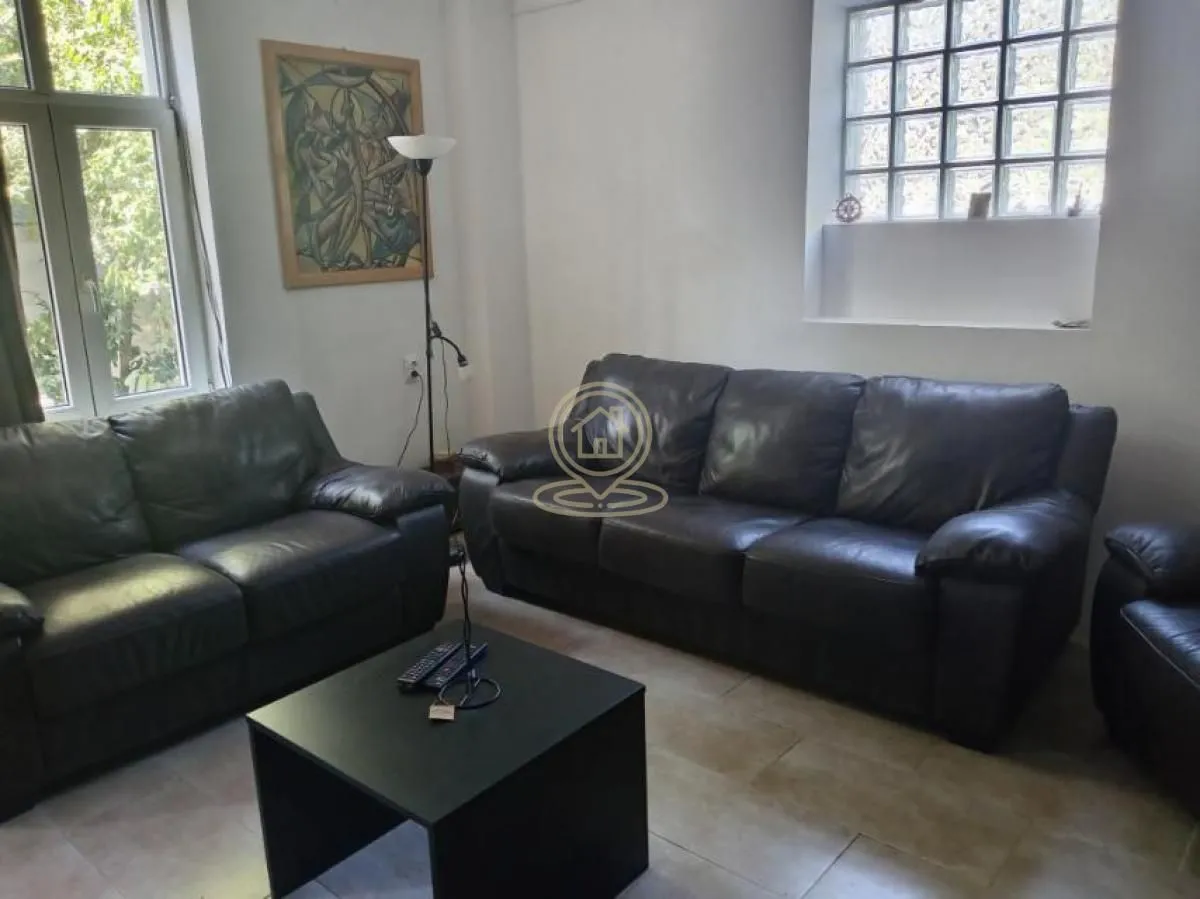Living room with black leather sofas and a coffee table.