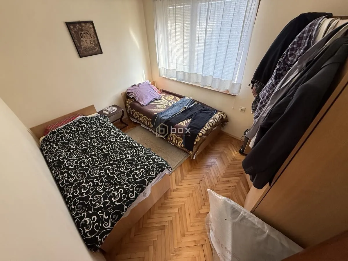 Spavaća soba sa dva kreveta i garderoberom.