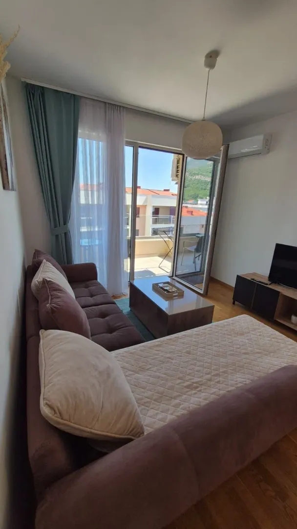 Living room with a sofa, coffee table and access to the terrace.