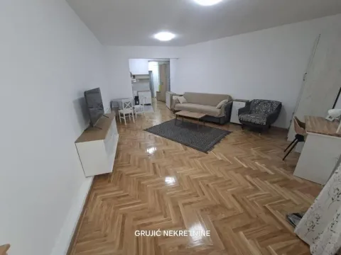 Living room with sofa, TV and wooden parquet flooring. - image 2