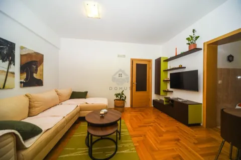 Living room with a sofa, TV, and wooden flooring. - image 27