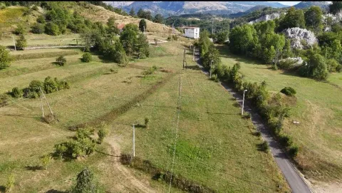Pogled iz vazduha na prostrano zemljište sa putem i rastinjem. - image 2