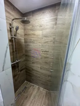 Modern walk-in shower with wood-effect tiles and a glass partition. - image 12
