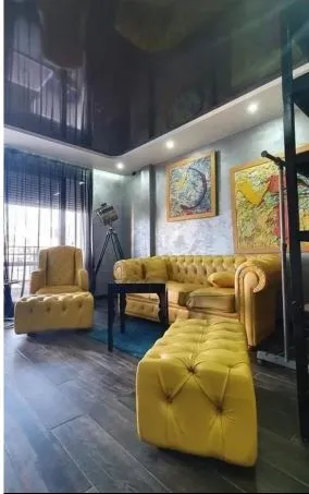 Moderan dnevni boravak sa žutim garniturama i tamnim plafonom.