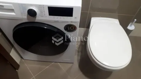 Bathroom with a washing machine and toilet. - image 6
