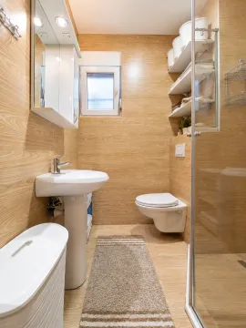 Bathroom with wood-pattern tiles featuring a washbasin, toilet, and shower enclosure. - image 3