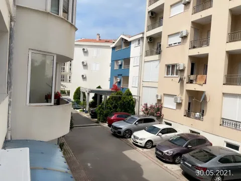 View from the apartment towards the courtyard with parking and surrounding buildings. - image 13