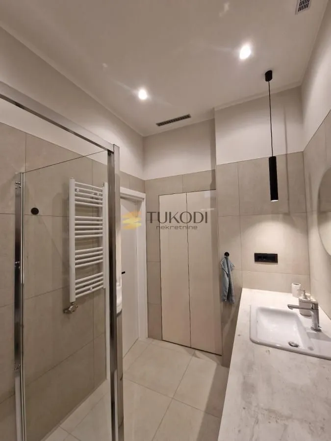 Modern bathroom with a walk-in shower and a sink.