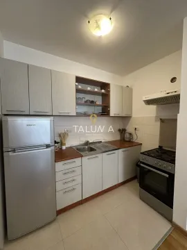 Compact equipped kitchen with white cabinets and a stove. - image 3