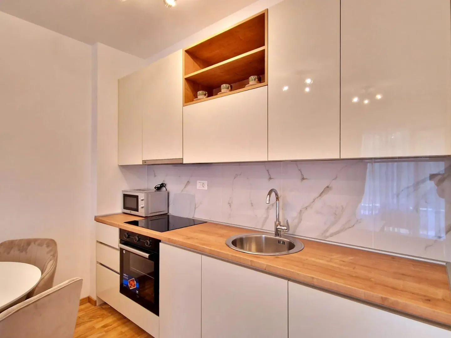 Modern kitchen with wooden countertop and built-in appliances.