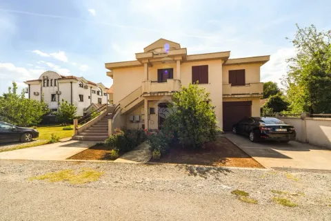 Front view of a multi-story house with a landscaped yard and parking space. - image 15