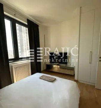 Furnished bedroom with a double bed, wardrobe, and TV. - image 4