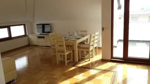 Svijetla trpezarija sa drvenim stolom i izlazom na terasu. - image 5