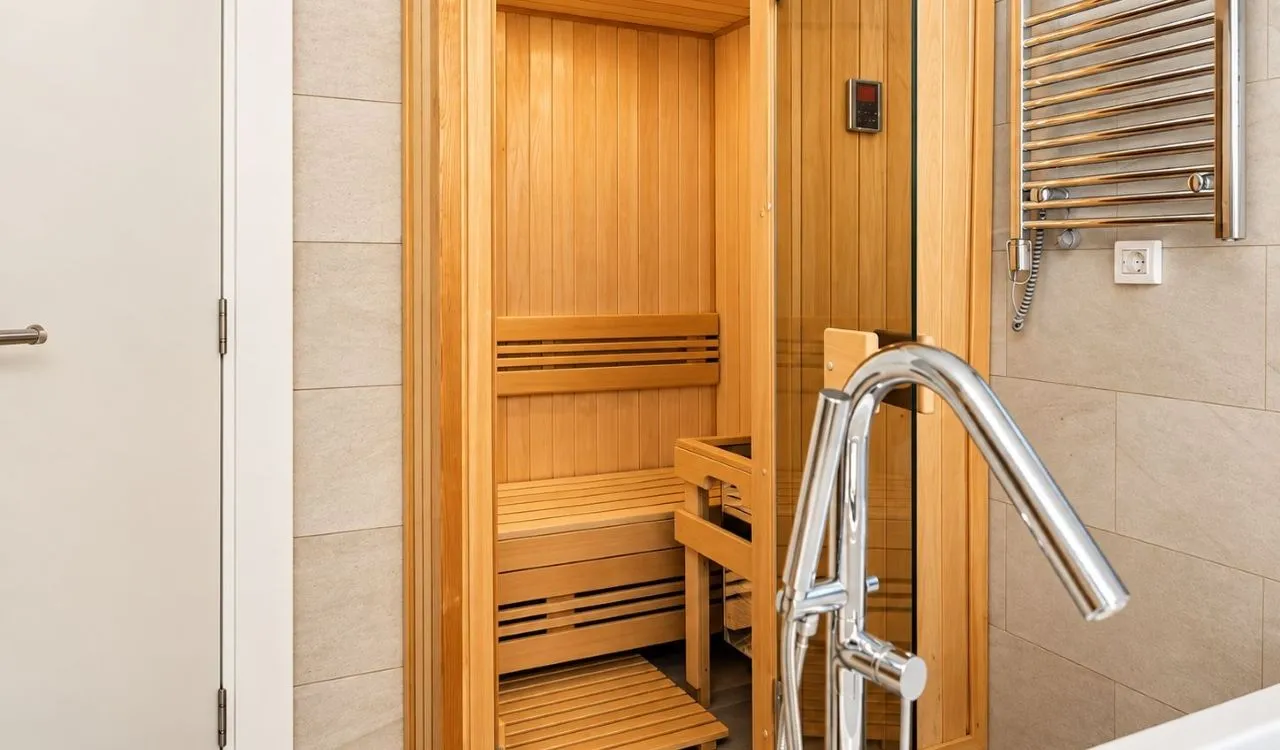 Bathroom with a wooden sauna and a shower.