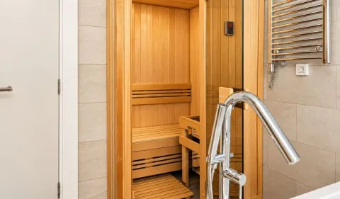 Bathroom with a wooden sauna and a shower. - image 14