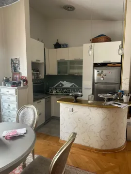 Manja kuhinja sa belim elementima, frižiderom i šankom povezana sa trpezarijom. - image 7