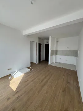 Prazna prostorija u novogradnji sa postavljenim laminatom i belim zidovima. - image 3