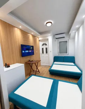 Namještena spavaća soba sa krevetima i televizorom. - image 5