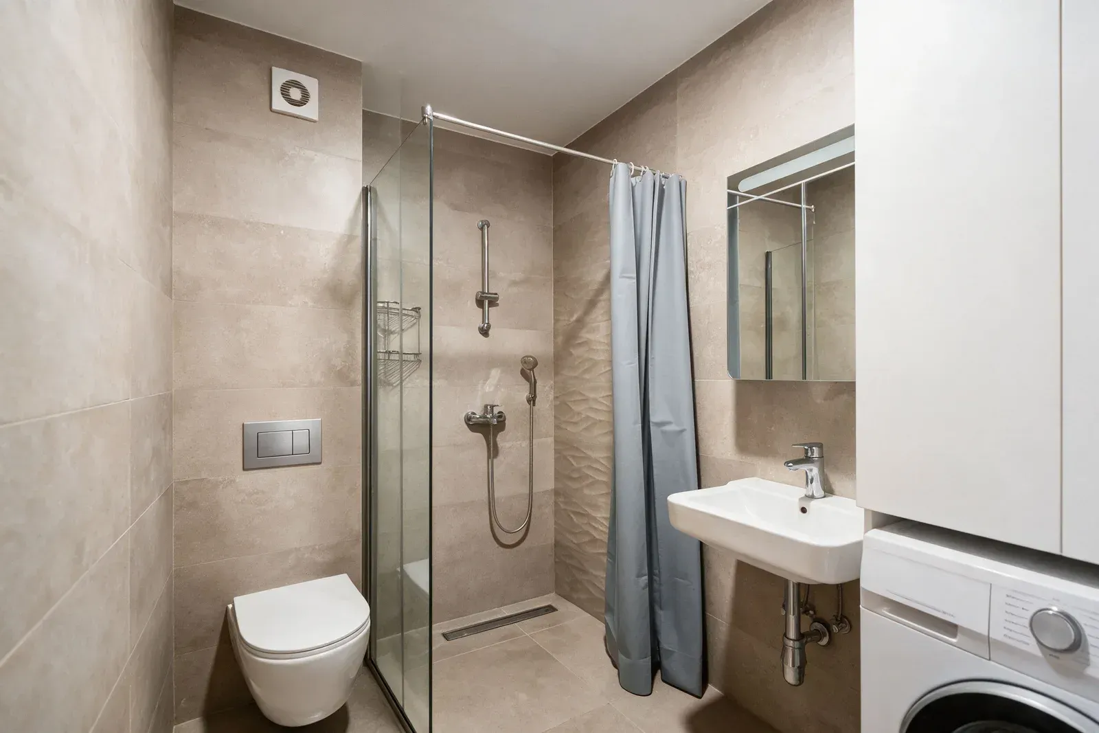 Moderne opremljeno kupatilo sa tuš kabinom, umivaonikom i WC šoljom.