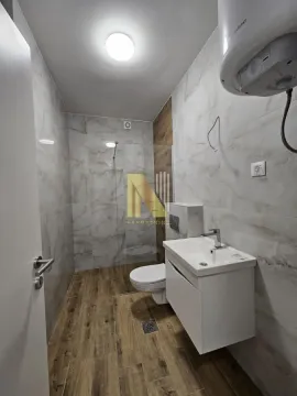 Moderno opremljeno kupatilo sa tuš kabinom i belim umivaonikom. - image 9