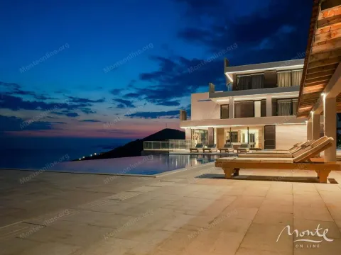 Exterior of the villa with a swimming pool and sea view at dusk. - image 2