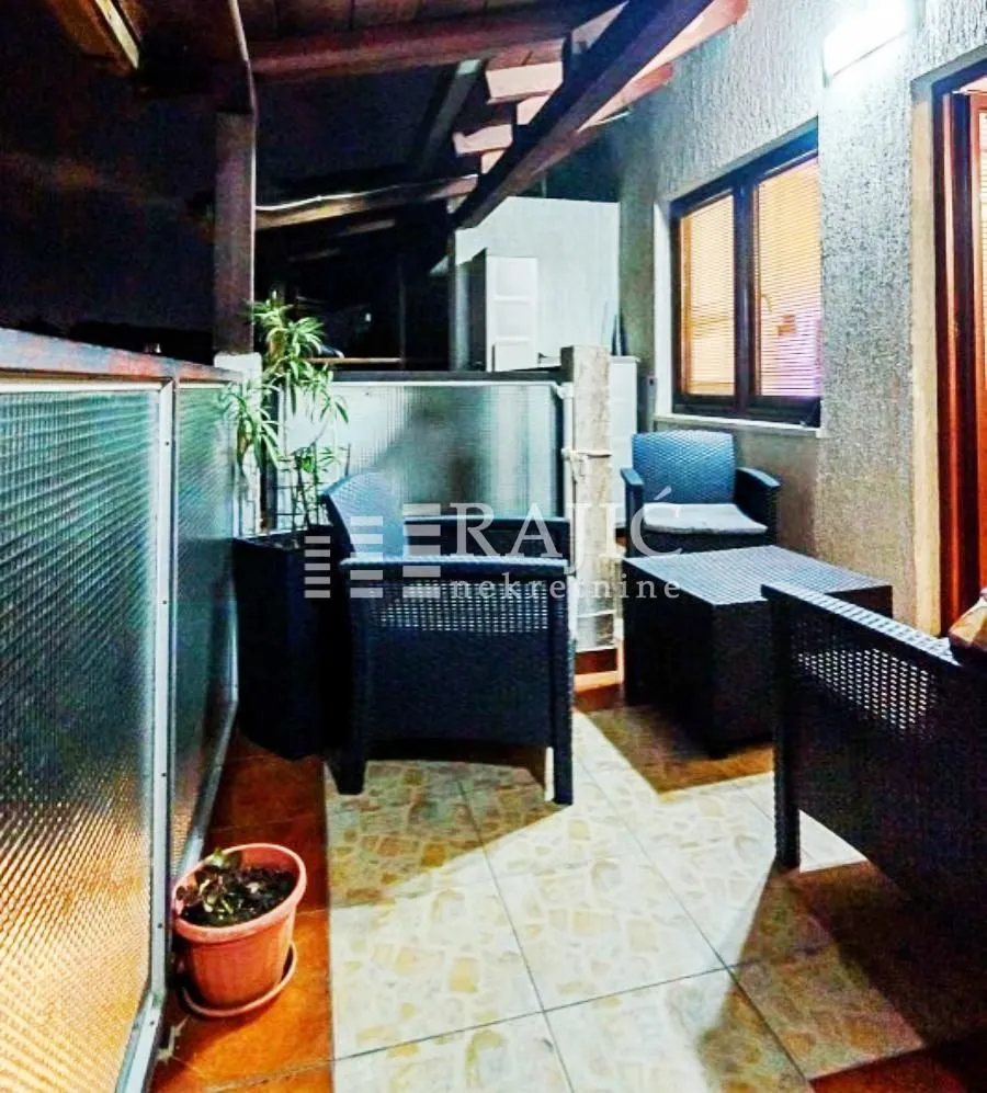 Covered terrace with seating furniture.