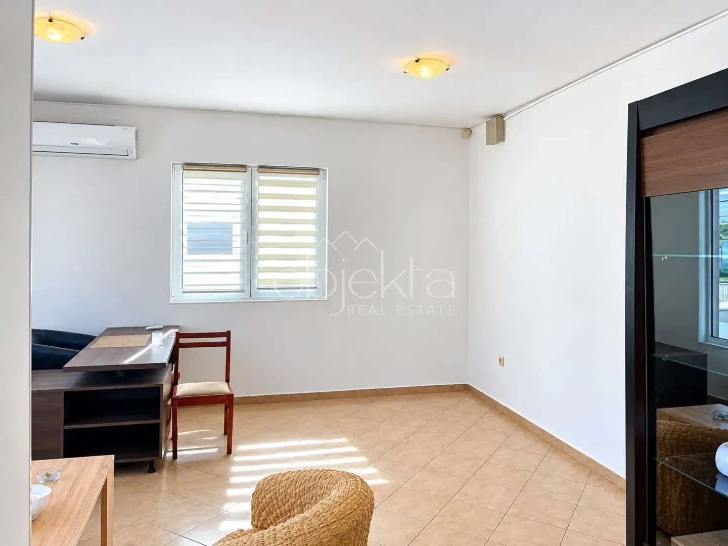 Bright room with a desk, air conditioning unit, and a window.
