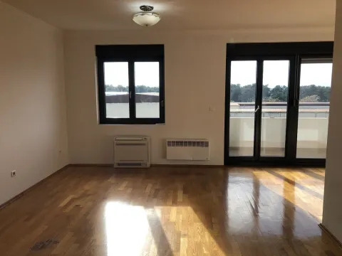 Empty room with parquet flooring, windows, and balcony doors. - image 4