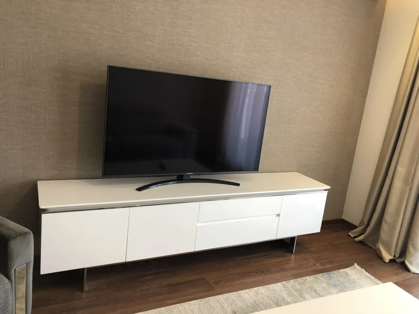 A modern TV stand with a television in a living room.