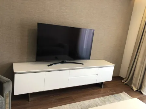 A modern TV stand with a television in a living room. - image 20