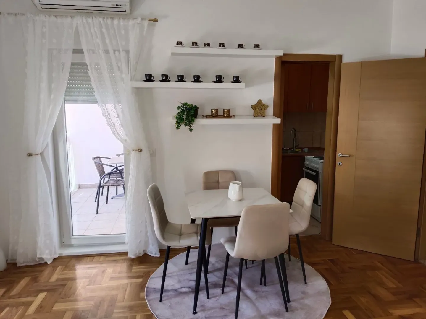 Dining area with a table, chairs, and wall shelves.