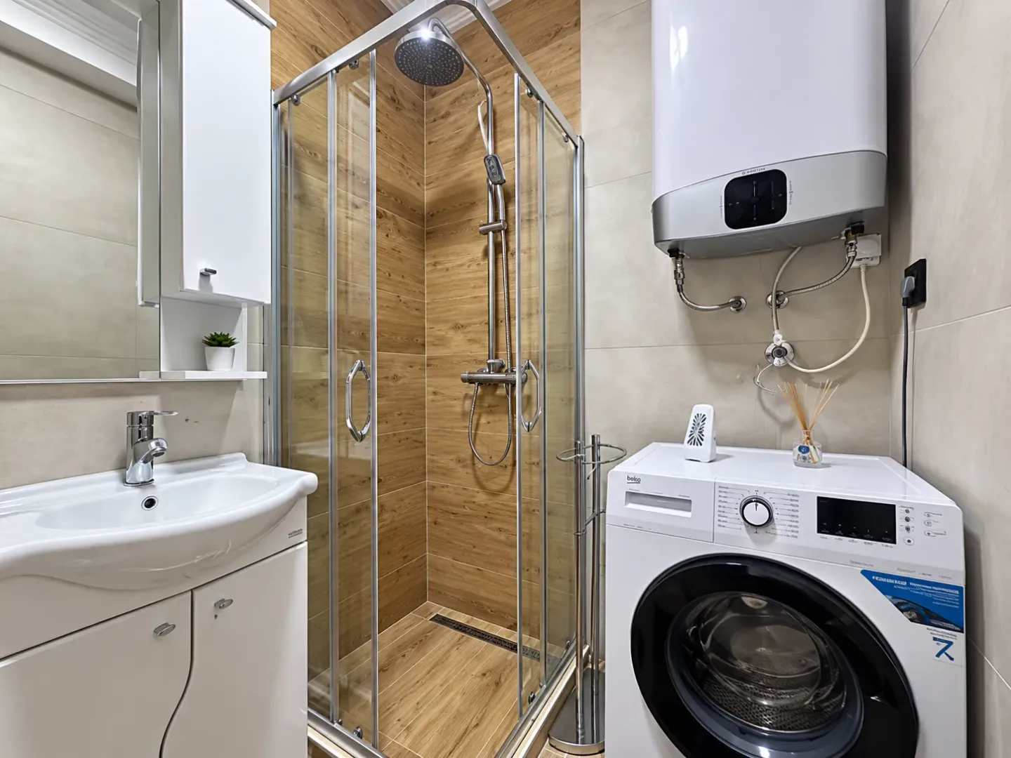 Bathroom with a shower cabin, washbasin, and washing machine.