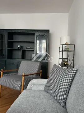 Dnevni boravak sa garniturom za sedenje i crnim ormarom. - image 2