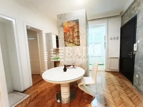 Living room with a dining table and parquet flooring. - image 2