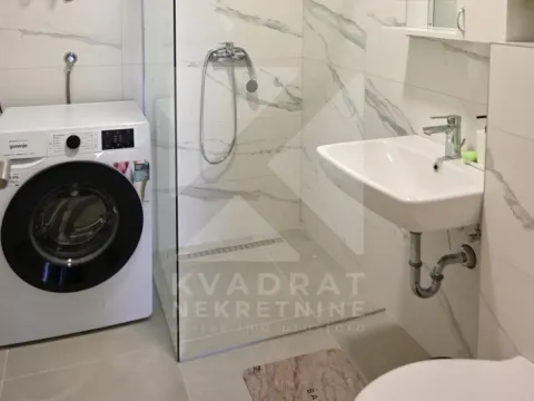 Savremeno opremljeno kupatilo sa tuš kabinom i veš mašinom. - image 6
