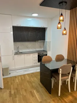 Svijetla kuhinja sa trpezarijskim stolom i modernim visećim svjetiljkama. - image 7