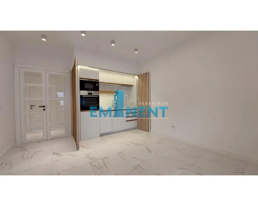 Small modern kitchen with built-in appliances and white ceramic floor tiles.