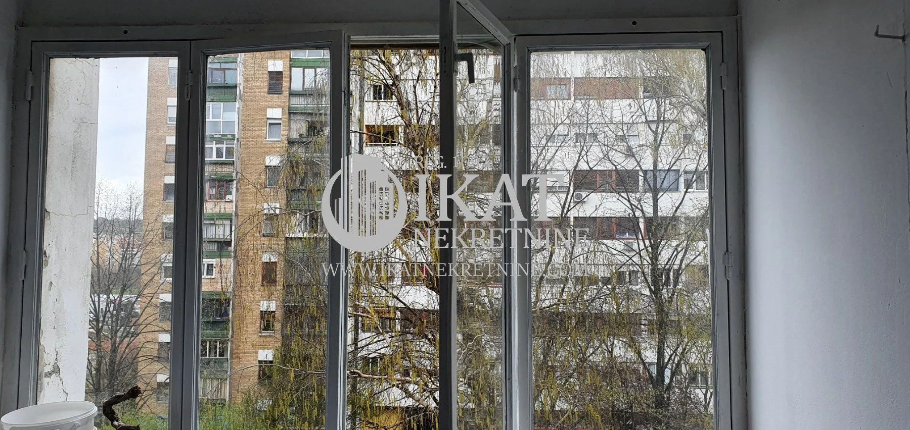 View through the window overlooking surrounding buildings and trees.