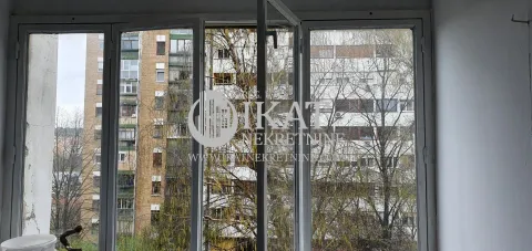 View through the window overlooking surrounding buildings and trees. - image 18